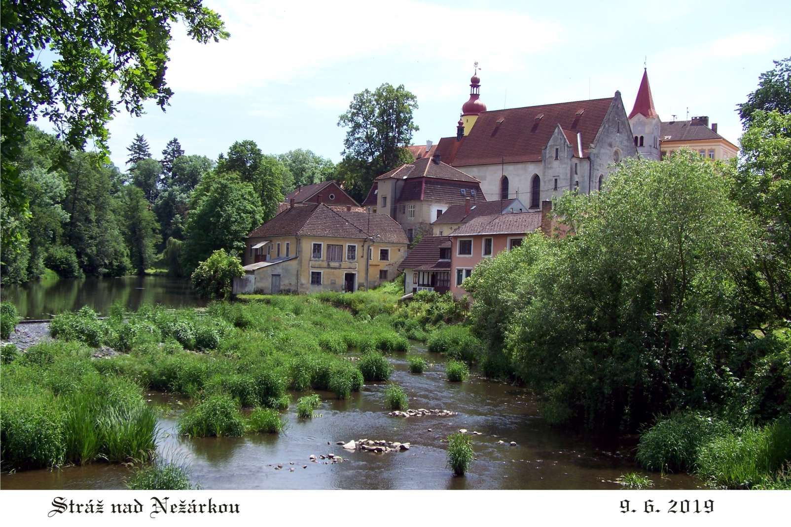 Romantický pohled na zámek, kostel a řeku.